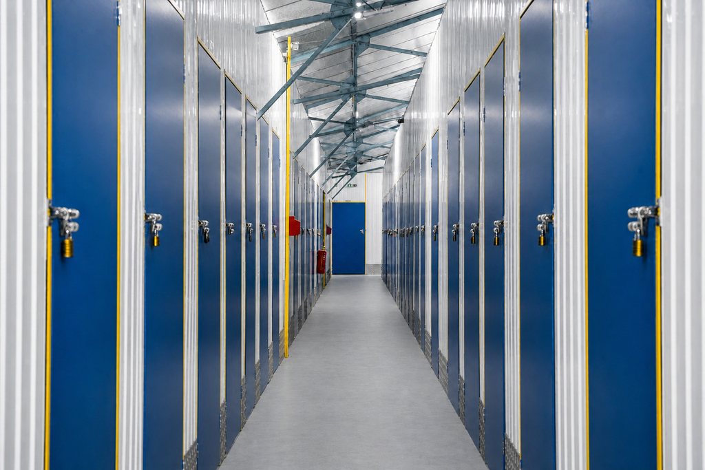 Couloir du centre bordé de portes bleues fermées par des cadenas
