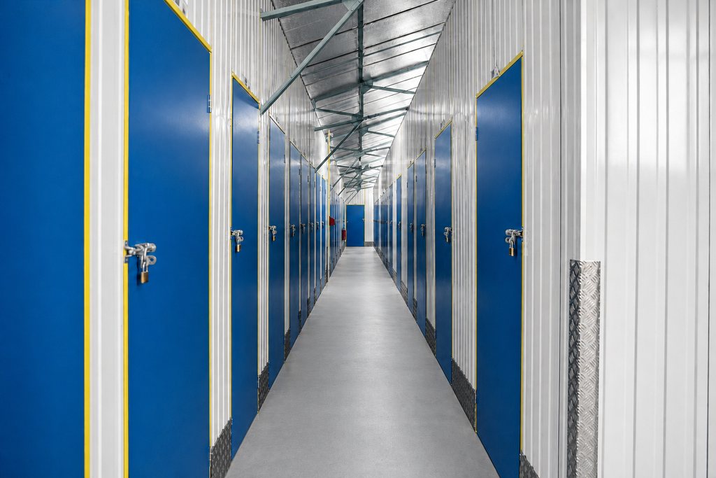 Couloir du centre : des portes bleues alignées de part et d’autre, cloisons blanches