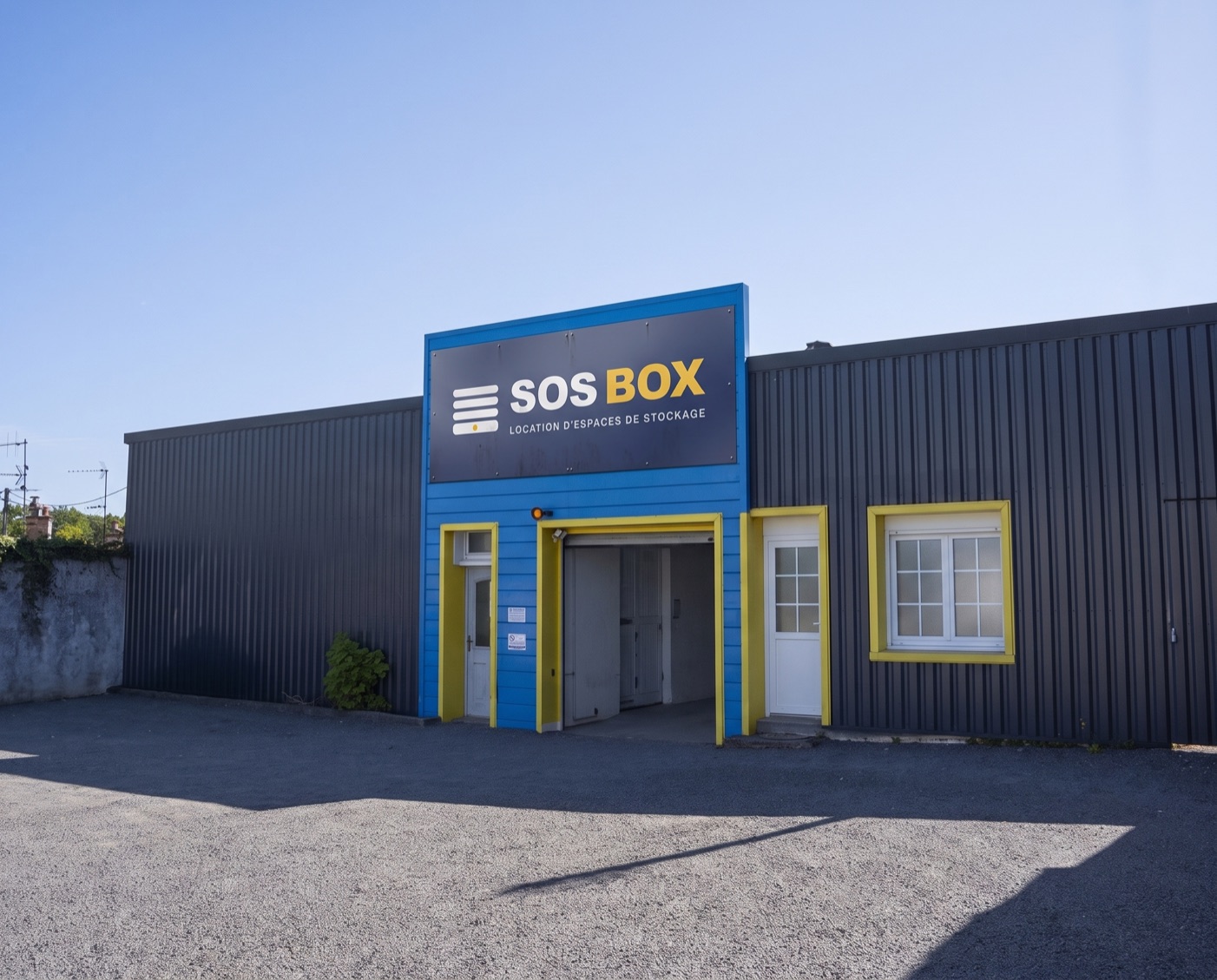 La façade bleue de SOS BOX en plein jour, enseigne et encadrements jaunes, 8 rue Jean Marchais à Angoulême